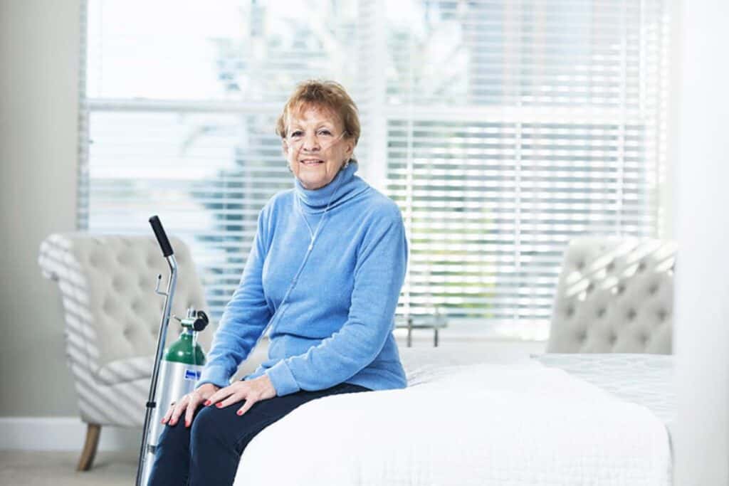 Women sitting home with oxygen concentrator equipment